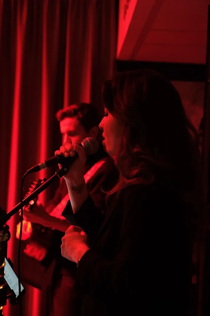 Marie-Amélie au micro pendant un concert intimiste en lumière rouge